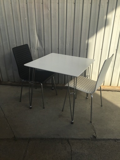 白いテーブルと白黒の椅子２脚