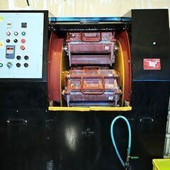 自動車部品工場内で自動研磨機械のオペレーター